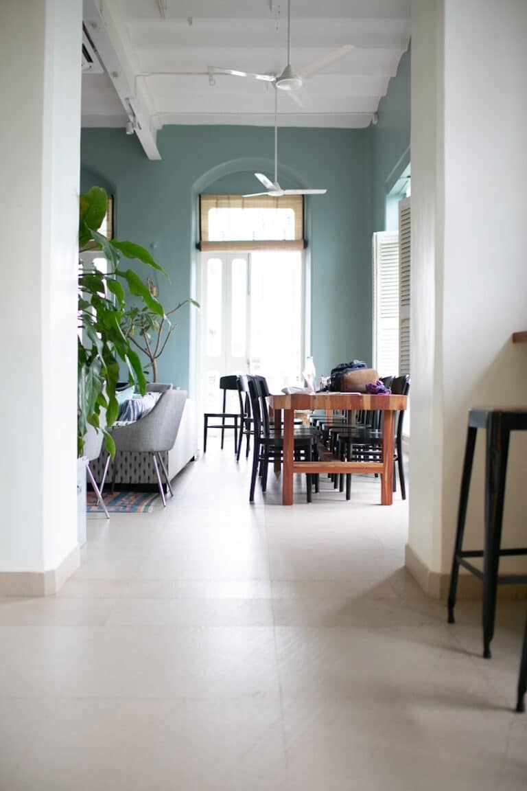 two white ceiling fans turned-off under brown table and chairs